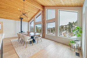 Dining area with a healthy amount of sunlight, light wood finished floors, wood ceiling, and visible vents