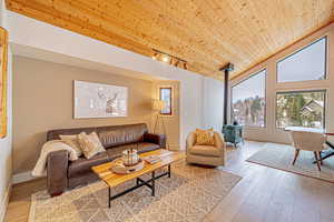 Living room featuring wood ceiling, vaulted ceiling, and wood-type flooring