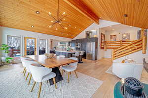 Dining space with a chandelier, recessed lighting, wood ceiling, light wood finished floors, and beamed ceiling