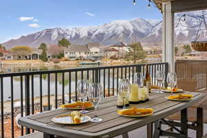 Balcony with a residential view, outdoor dining area, and a water and mountain view