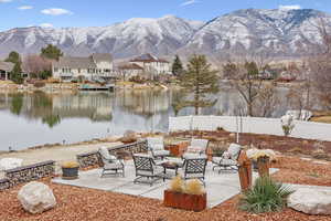 View of patio / terrace featuring fence, a fire pit, and a water and mountain view