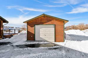 Snow covered garage with a garage