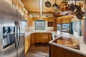 Kitchen featuring a healthy amount of sunlight, wooden ceiling, stainless steel appliances, and light countertops