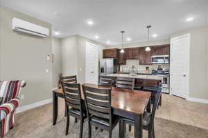 Dining area featuring light carpet, recessed lighting, baseboards, a wall mounted air conditioner, and light tile patterned flooring