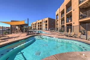 Community pool featuring a patio area and fence