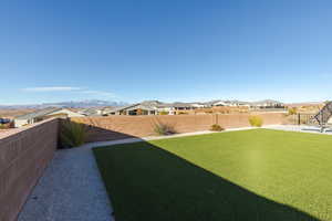 View of yard with a residential view, a fenced backyard, and a mountain view