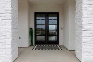 Doorway to property featuring french doors and brick siding