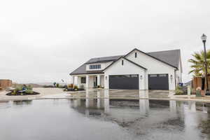 Modern farmhouse with concrete driveway and an attached garage