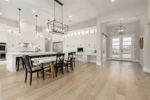 Dining area with light wood-type flooring, recessed lighting, baseboards, and french doors