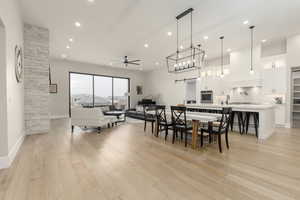 Dining room with a ceiling fan, recessed lighting, light wood-style flooring, and a barn door