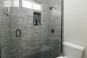 Full bathroom featuring toilet and a shower stall