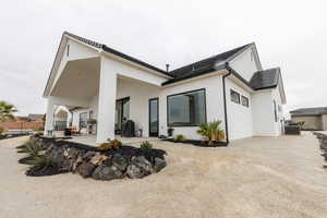 Rear view of property featuring a patio area, fence, central AC, and stucco siding