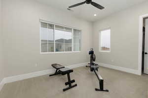 Workout area featuring recessed lighting, a healthy amount of sunlight, light colored carpet, and baseboards