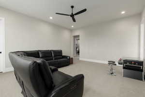 Living area with recessed lighting, light colored carpet, ceiling fan, and baseboards