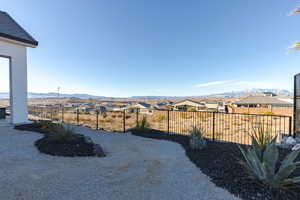 View of yard with a mountain view, a fenced backyard, and a residential view