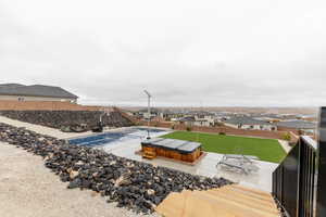 View of patio / terrace featuring a hot tub, a residential view, and a fenced backyard