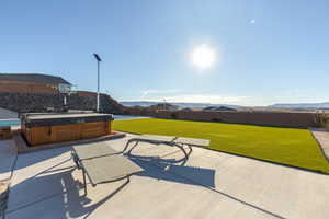 View of patio with a fenced backyard, a mountain view, and a hot tub