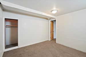 Unfurnished bedroom with a closet, carpet flooring, and visible vents