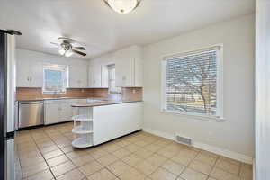 Kitchen featuring visible vents, white cabinets, a peninsula, stainless steel appliances, and open shelves