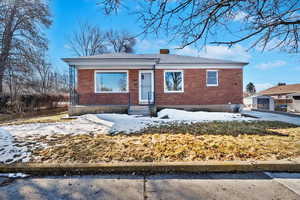 Bungalow with brick siding and a chimney