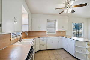 Kitchen featuring a sink, open shelves, light countertops, and white cabinetry