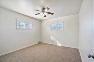 Carpeted empty room featuring visible vents, baseboards, and a ceiling fan