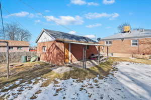 Snow covered property with brick siding