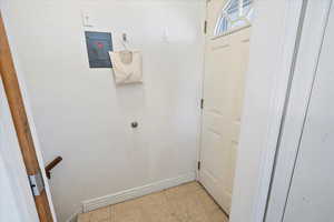 Doorway to outside with light tile patterned floors and baseboards