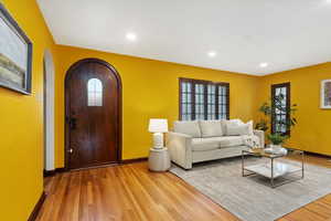 Unfurnished living room with light wood-type flooring, arched walkways, baseboards, and recessed lighting