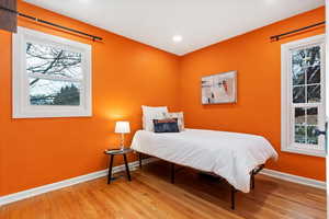 Bedroom with baseboards, wood finished floors, and recessed lighting