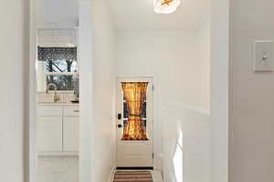 Doorway with marble finish floor and a sink