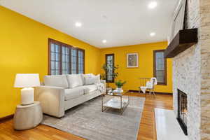 Living area featuring recessed lighting, a fireplace, light wood-style flooring, and baseboards