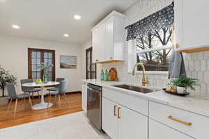 Kitchen with a sink, white cabinetry, and dishwasher