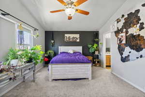 Bedroom featuring light colored carpet, vaulted ceiling, and baseboards