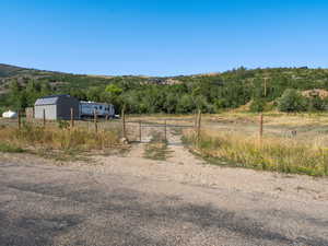 View of road with driveway, a gate, a gated entry, and a rural view