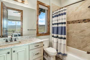 Ensuite bathroom with toilet, ensuite bathroom, shower / bath combination with curtain, vanity, and a mountain view