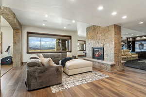 Living room with a fireplace, wood finished floors, and recessed lighting