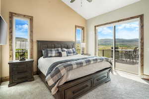 Bedroom featuring light colored carpet, vaulted ceiling, a mountain view, ceiling fan, and access to outside