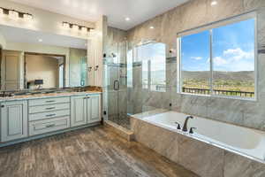 Bathroom with a garden tub, double vanity, a mountain view, a shower stall, and a sink