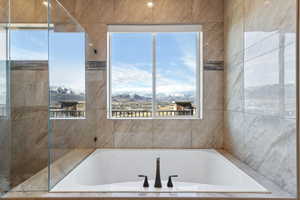 Bathroom with a garden tub and a mountain view