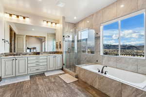 Bathroom with a sink, double vanity, wood finished floors, and a shower stall