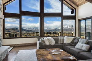 Living area featuring high vaulted ceiling, wooden ceiling, a mountain view, and wood finished floors