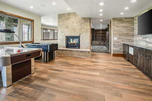 Kitchen featuring dark brown cabinets, recessed lighting, a fireplace, and light wood-style floors