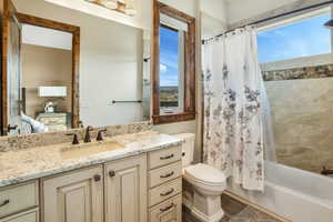 Bathroom with toilet, shower / tub combo, wood finished floors, and vanity