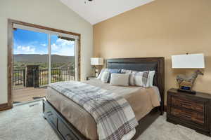 Bedroom with light carpet, visible vents, lofted ceiling, access to outside, and a mountain view