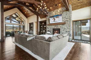 Living area featuring high vaulted ceiling, wooden ceiling, dark wood finished floors, and a notable chandelier