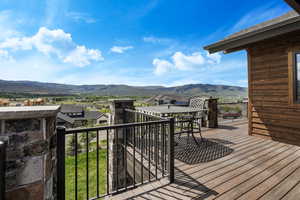 Wooden deck with a residential view, a mountain view, and outdoor dining area