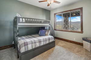 Bedroom featuring carpet flooring, a mountain view, baseboards, and ceiling fan