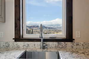 Interior details featuring a sink, a mountain view, and light stone countertops