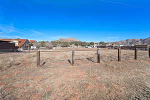 View of yard featuring a rural view, a mountain view, and fence